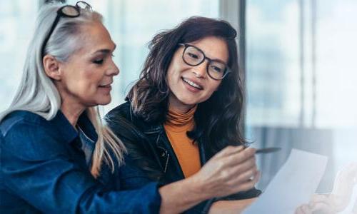 Two business analysts reviewing data in report 